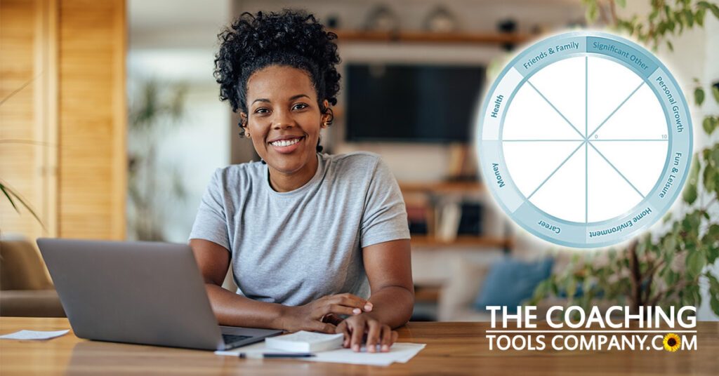 Coach at desk with laptop learning how to measure progress in coaching with a life wheel
