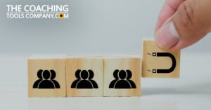 Hand holding magnet cube attracting people cubes