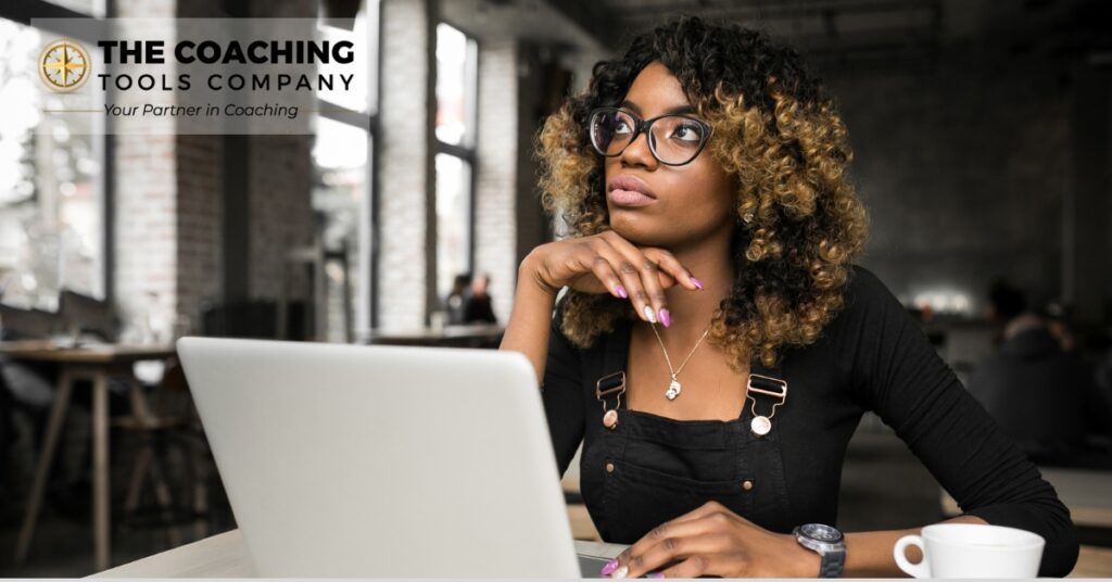 Female coach sitting thoughtfully, reflecting on personal and professional growth