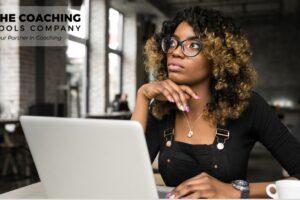 Female coach sitting thoughtfully, reflecting on personal and professional growth
