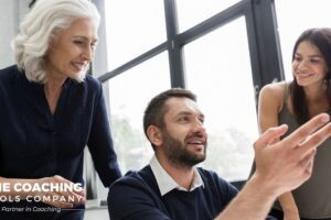 A team collaborating around a screen, reflecting shared coaching capacity in the era of AI.